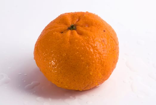 Juicy tangerine covered by drops of water. Isolated on white background