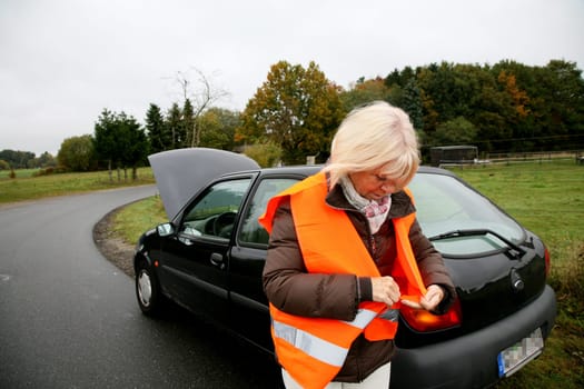 Senior woman puts on traffic vest
