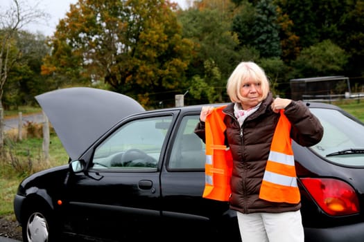 Senior woman puts on traffic vest