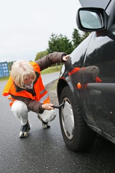 Senior citizen checks car tires