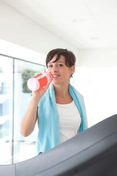 beauty girl drink water on treadmill