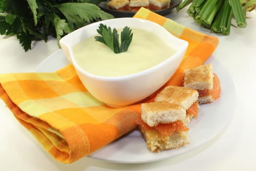 a bowl of cream of celery soup with salmon croutons