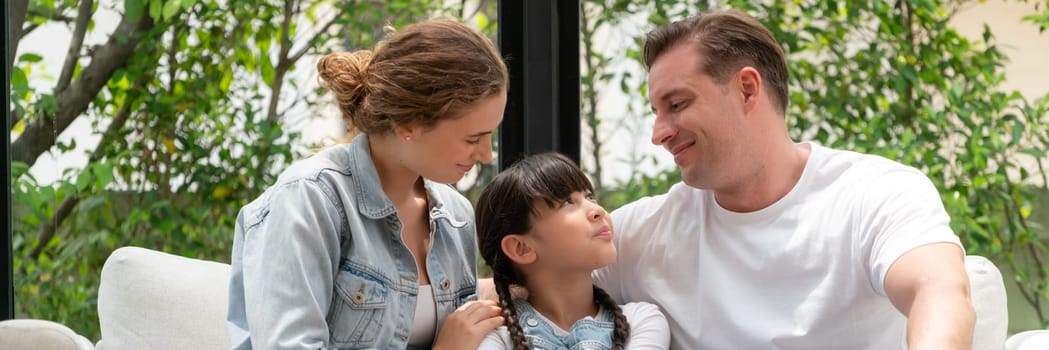 Parents comforting their daughter with loving hug, helping her feel secure and protected from fear, rest her head on shoulder. Happy family love and child care support concept. Panorama Synchronos