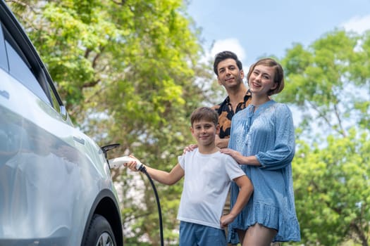 Family road trip vacation with electric vehicle, lovely family recharge EV car with green and clean energy. Natural and eco friendly car travel for sustainable environment. Perpetual