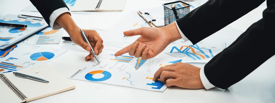 Business people in group meeting in formal attire share idea discussing report for company profit in creative workspace for start up business shot in close up view on group meeting table . Oratory .