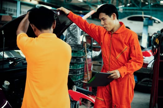 Automotive service mechanic inspect and diagnose car engine issue, repairing and fixing problem in garage workshop. Technician car care maintenance working on internal components of vehicle. Oxus
