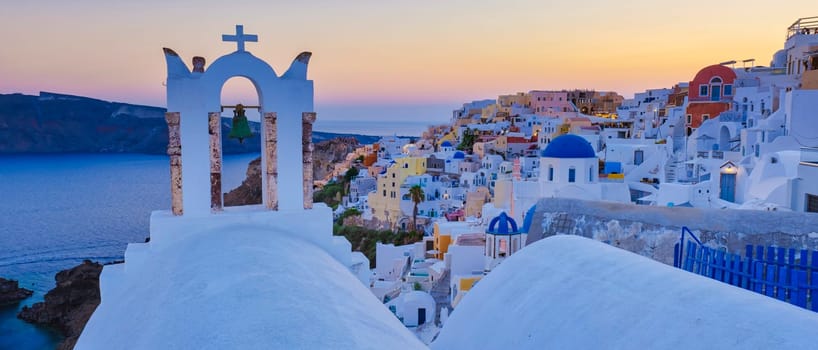 Santorini Greece at sunset, White churches and blue domes by the ocean of Oia Santorini Greece, a traditional Greek village in Santorini at sunset