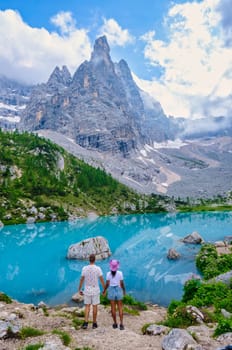 Lago di Sorapis in the Italian Dolomites, milky blue lake Lago di Sorapis, Lake Sorapis, Dolomites, Italy during summer, couple hiking in the Italian mountains of the Dolomites during summer holidays