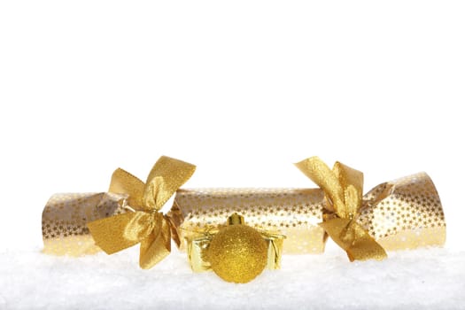 Christmas surprise with bows and golden ball lying in the snow against white background