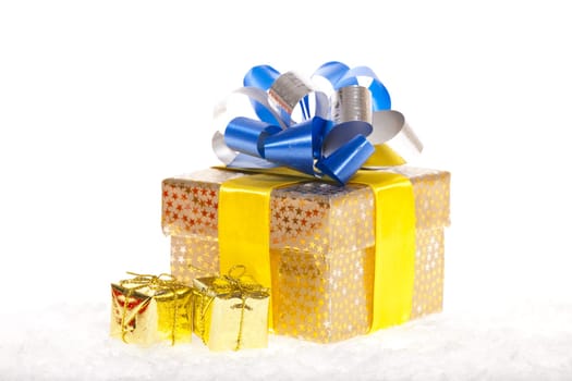 Package with bow and small Christmas packages lying in the snow against white background
