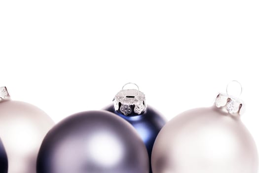Close-up of blue and silver baubles on white background
