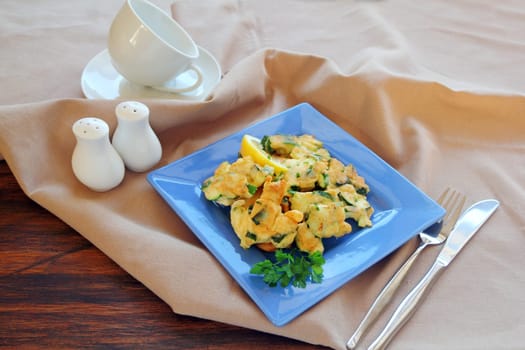 Delicious and delicate freshly fried courgette fritters with parsley ready to serve.