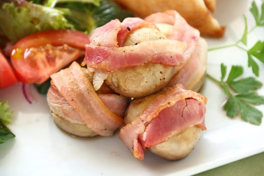 Delicious bacon wrapped mushrooms served with a fresh garden salad.