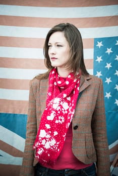 Vintage style fashion shot of beautiful young woman in front of US and UK flags