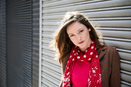 Portrait of fashionable young woman leaning against garage doors