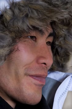 man in outline who looks asian or inuit with coat above his head