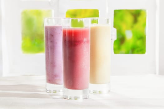 Variety of healthy fresh fruit t smoothies in glasses made from a blend of creamy yoghurt and liquidised fruit