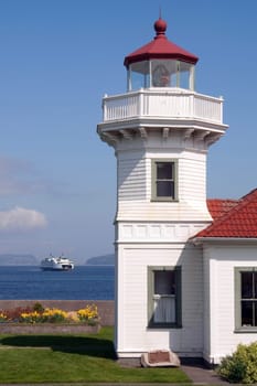A ferry crosses the Puget Sound behind the Lighthouse