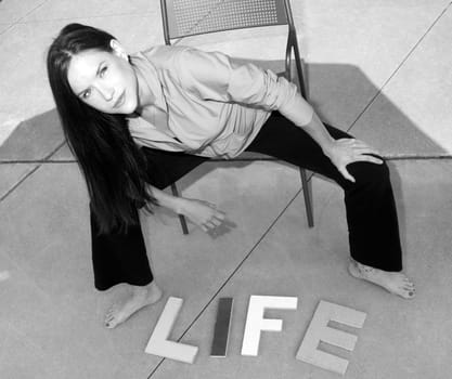 Attractive woman on concrete with letter that say LIFE