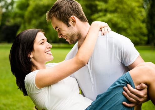 Young happy couple enjoying life - man carrying woman