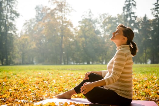 Happy pregnant woman looking to sky in autumn beautiful nature
