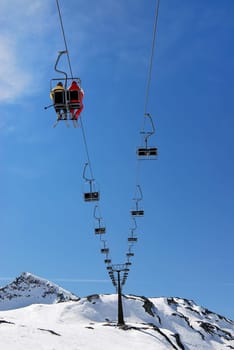 Winter snow scene of people sitting on emty ski lift
