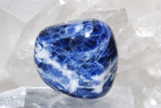 Indigo coloured sodalite gem energized on druze of quartz crystals. This gem is used as a jewel stone and also in alternative medicine and esoterics (connected with 6th chakra).