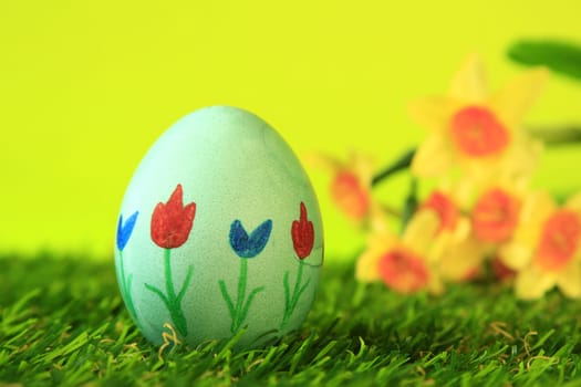 Easter decoration made of single,colorfully painted,Easter egg in green artificial grass