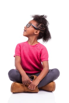 Portrait of a cute young African American girl seated on the floor