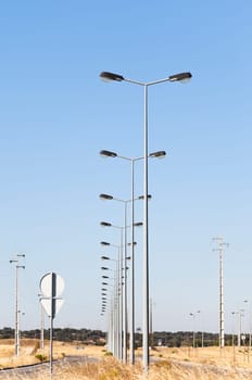 A long row of street lights in fully infra-structured vacant lots ready for construction in the industrial park of Evora, Portugal