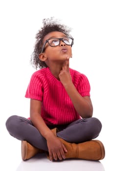Portrait of a cute young African American girl seated on the floor