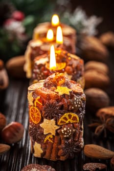 Rustic aromatic Christmas candles with spices and nuts