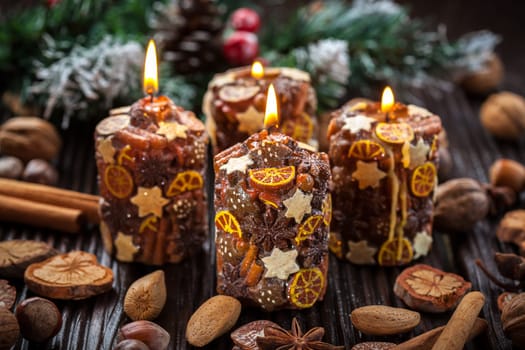 Rustic aromatic Christmas candles with spices and nuts