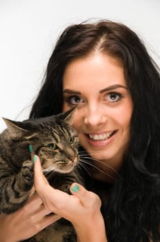 Head and shoulders shot of young black-haired woman with tiger cat on her arms and looking at camera