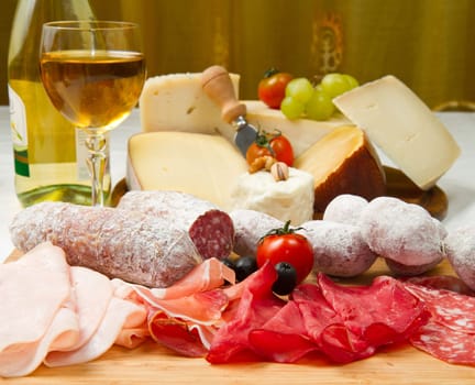 composition of cold cuts  on wooden board with different type of cheese