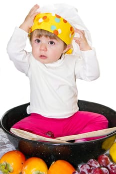 Baby cook with vegetables in studio