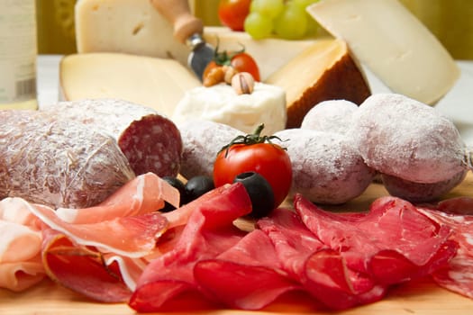 composition of cold cuts  on wooden board with different type of cheese