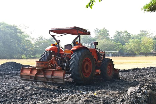 The tractor gravel Rouge in Football field.