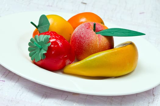Marzipan fruit isolated on white dish