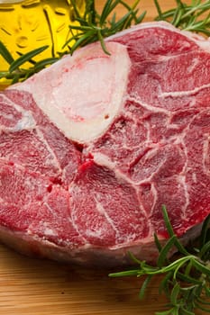 raw marrowbone on wooden board with rosemary