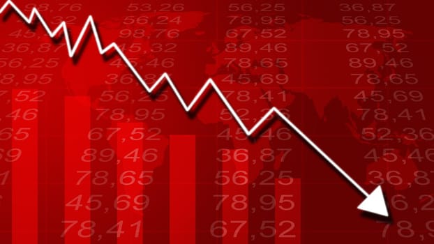 Arrow graph going down and electronic stock numbers on a blue background.