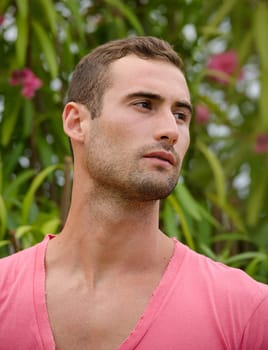 Portrait of handsome guy in front of green plants