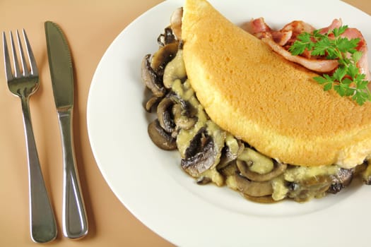 Delicious mushroom omelette with cheese, bacon and parsley ready to serve for breakfast.