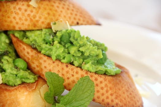 Delicious green pea baguettes with shaved cheese and mint with avocado oil.