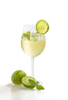 Aperitif with limes and mint in a wine glass