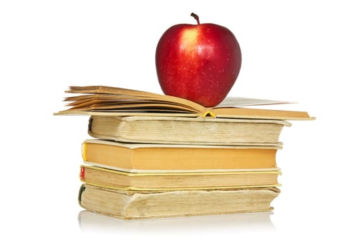 Red apple and stack of books with reflection on white background