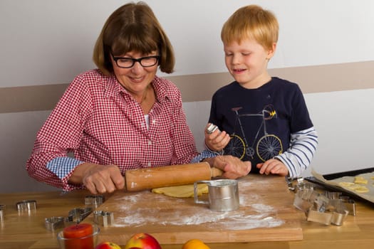 Grandma and grandchild cut out cookies