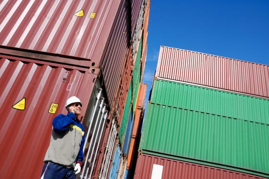 port and dock worker with stacks of containers in background