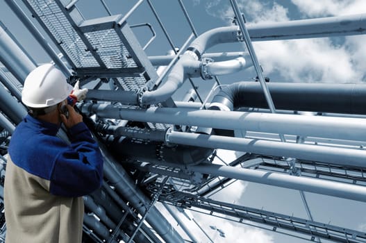 oil and gas worker with large pipeline construction in background