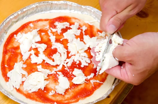 cook cuts the cheese inside the pizza with tomato